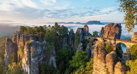 Bastei das maechtige Basteimassiv in der Saechsischen Schweiz mit der weltberuehmten Bruecke, im Hintergrund der Tafelberg Lilienstein