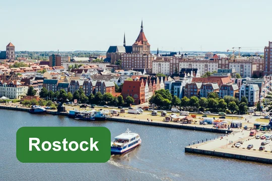 Rostock Panoramablick auf den Stadthafen und die Altstadt von Rostock, ergänzt durch das Textfeld ‚Rostock‘.